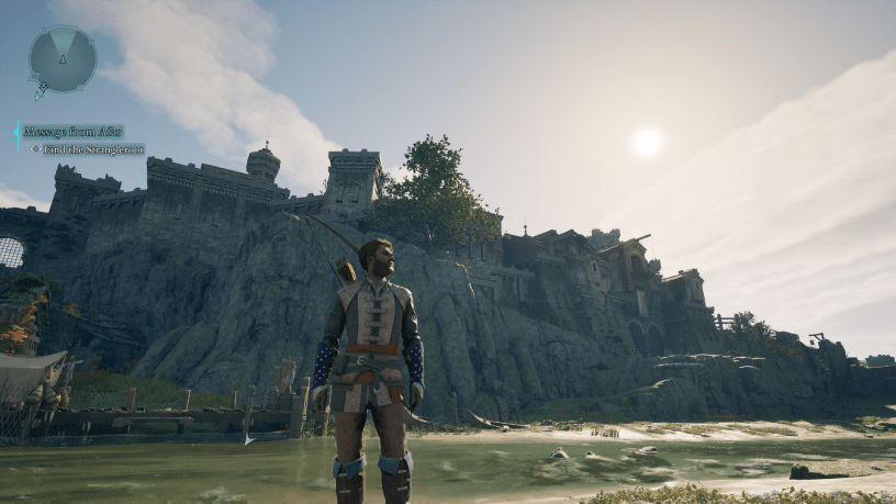 A warrior stands in shallow water, gazing at a grand medieval-style fortress on a rocky hill in Avowed. The sun casts a warm glow over the landscape, highlighting the game's detailed world.