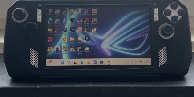ASUS ROG Ally Z1 Extreme handheld gaming PC displaying Windows 11 desktop with installed game launchers like Steam, EA, Epic Games, and Rockstar