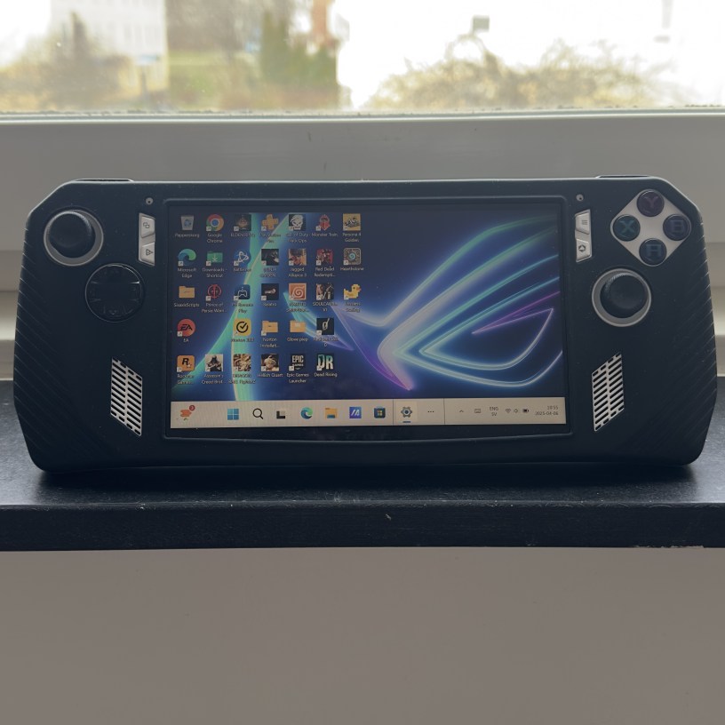 ASUS ROG Ally Z1 Extreme handheld gaming PC displaying Windows 11 desktop with installed game launchers like Steam, EA, Epic Games, and Rockstar